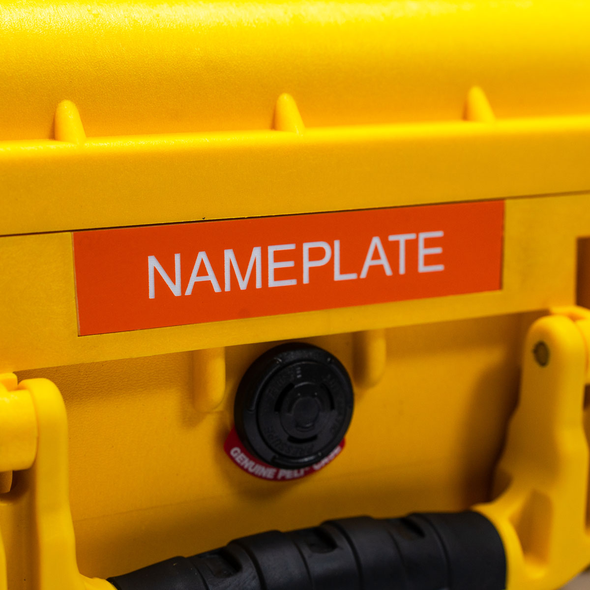 A customised orange nameplate attached to a yellow Peli case