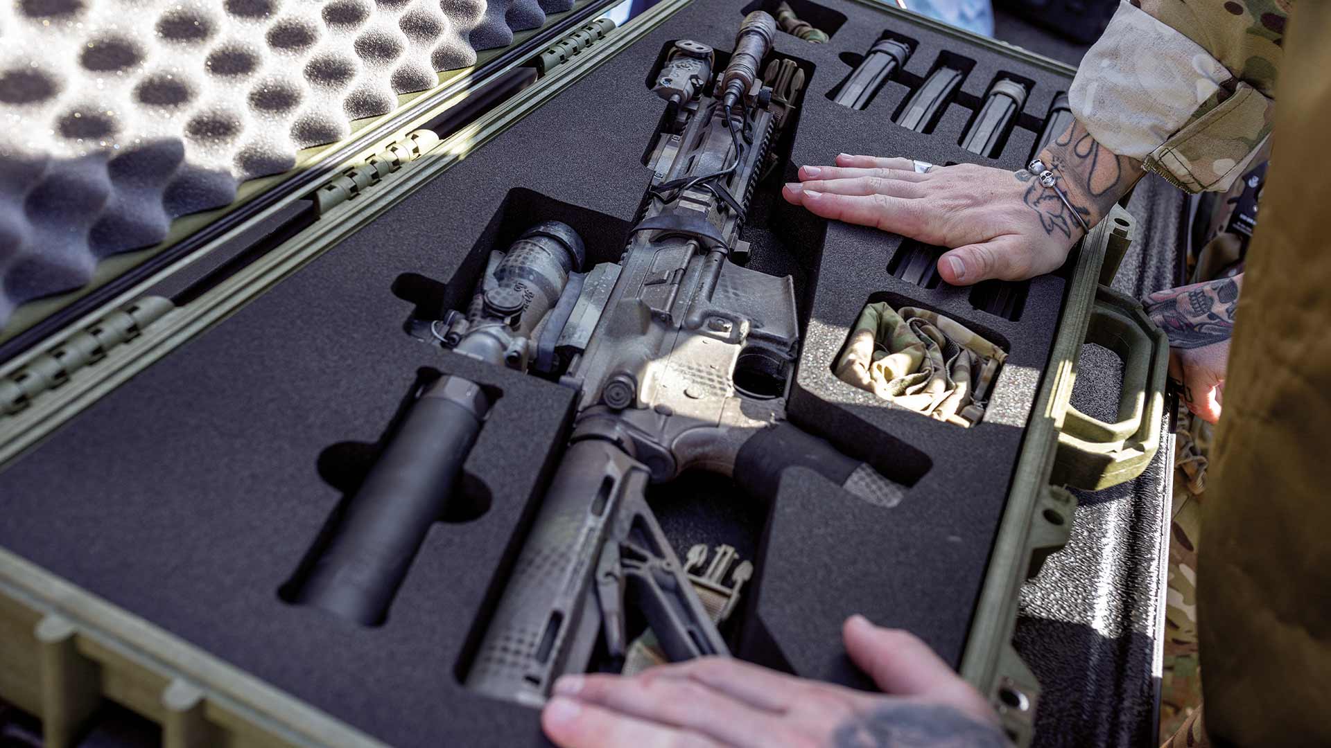 Custom foam insert inside a protective Peli case holding a rifle and accessories